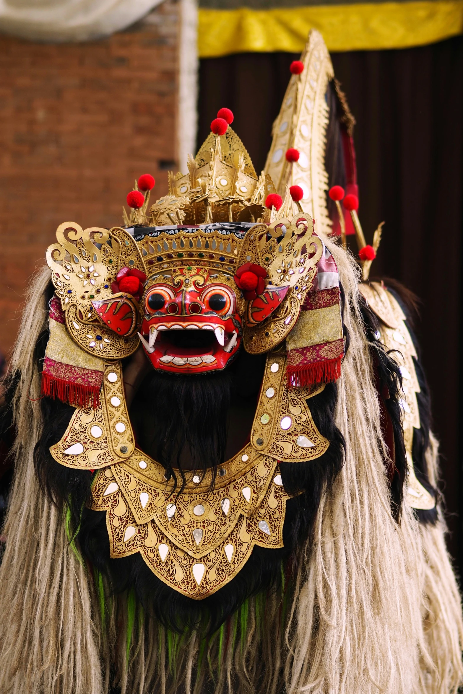 a costume is dressed with beads, feathers and an elaborate mask