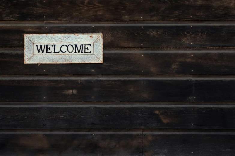 the welcome sign is displayed on the back of a wooden garage door