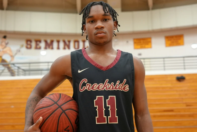 a young man wearing a jersey is posing with a basketball