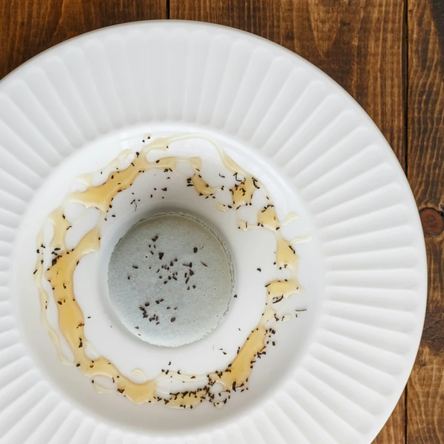 a small bowl of sauce sitting on top of a white plate