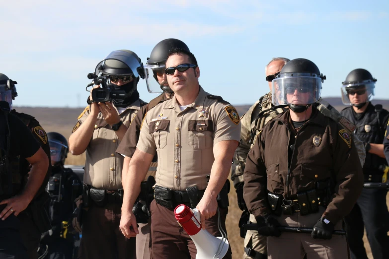 a police officer taking pictures with his camera and other men wearing protective gear