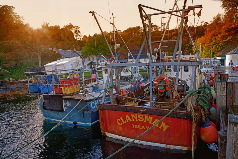 several fishing vessels tied to a dock in a harbor