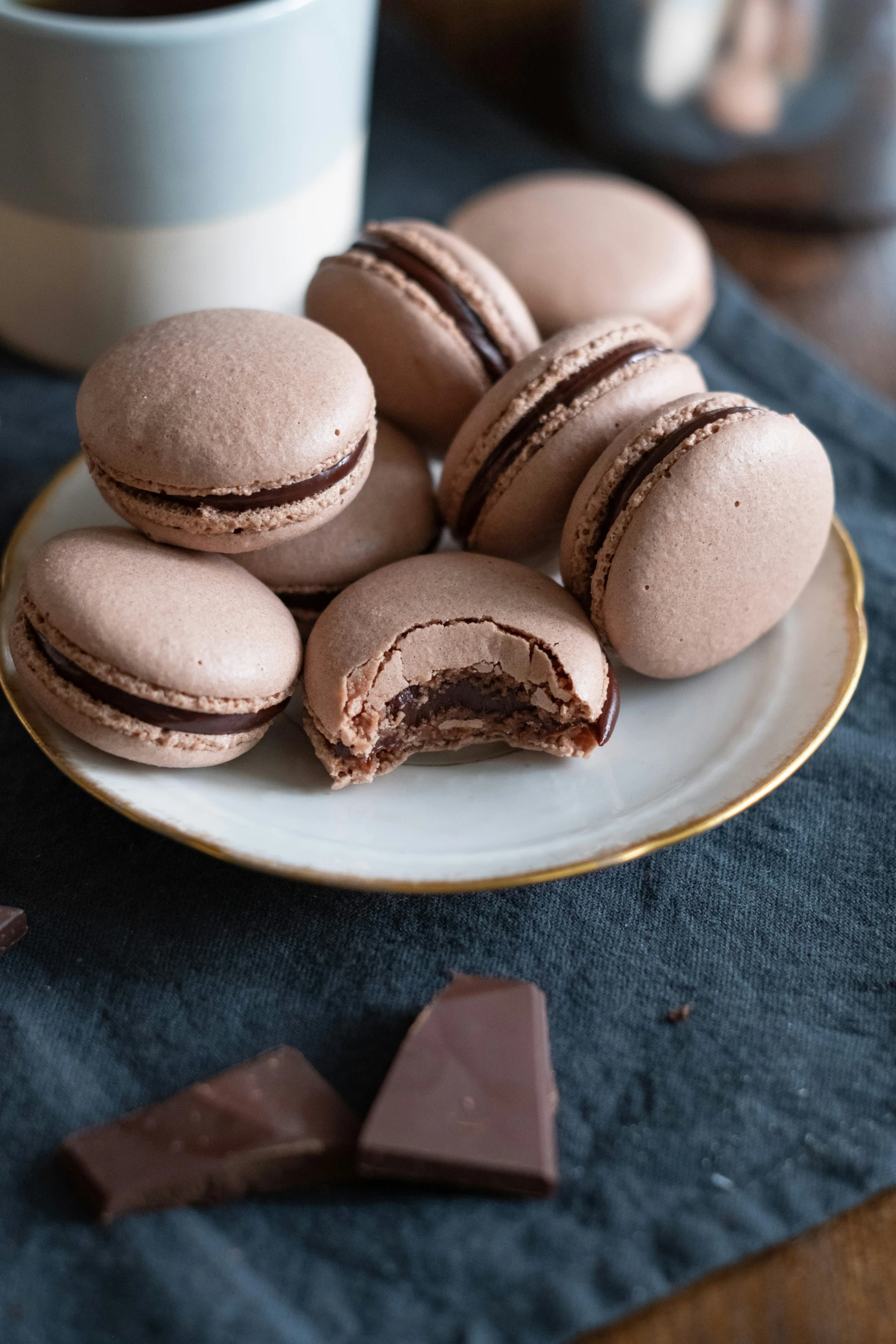 some cookies and chocolate are on a plate next to a cup of coffee