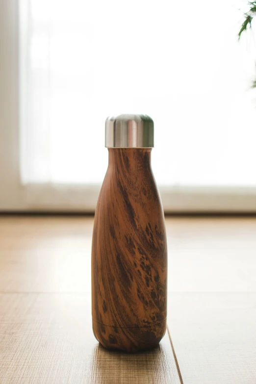 a wooden bottle that is on a floor