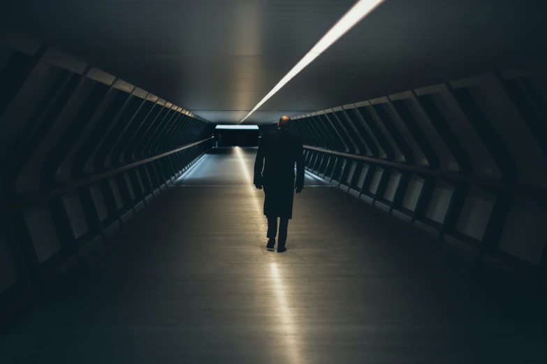 a person walking through a very dark tunnel