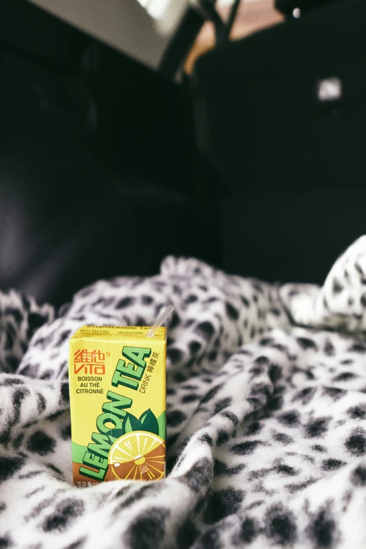 a box of lemon juice sitting on top of a leopard print bed spread