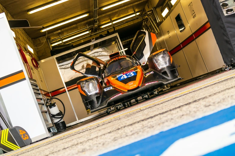 the two cars are in the pit area of a race track