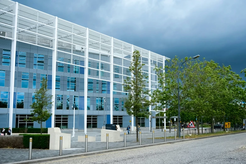 a grey and white building sitting in front of trees