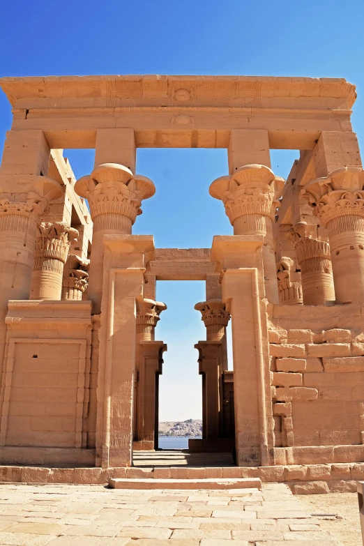 an ancient, detailed statue is set against a blue sky