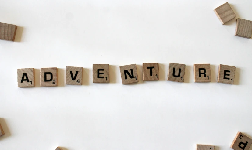 small scrabble type blocks spelling out the words adventure