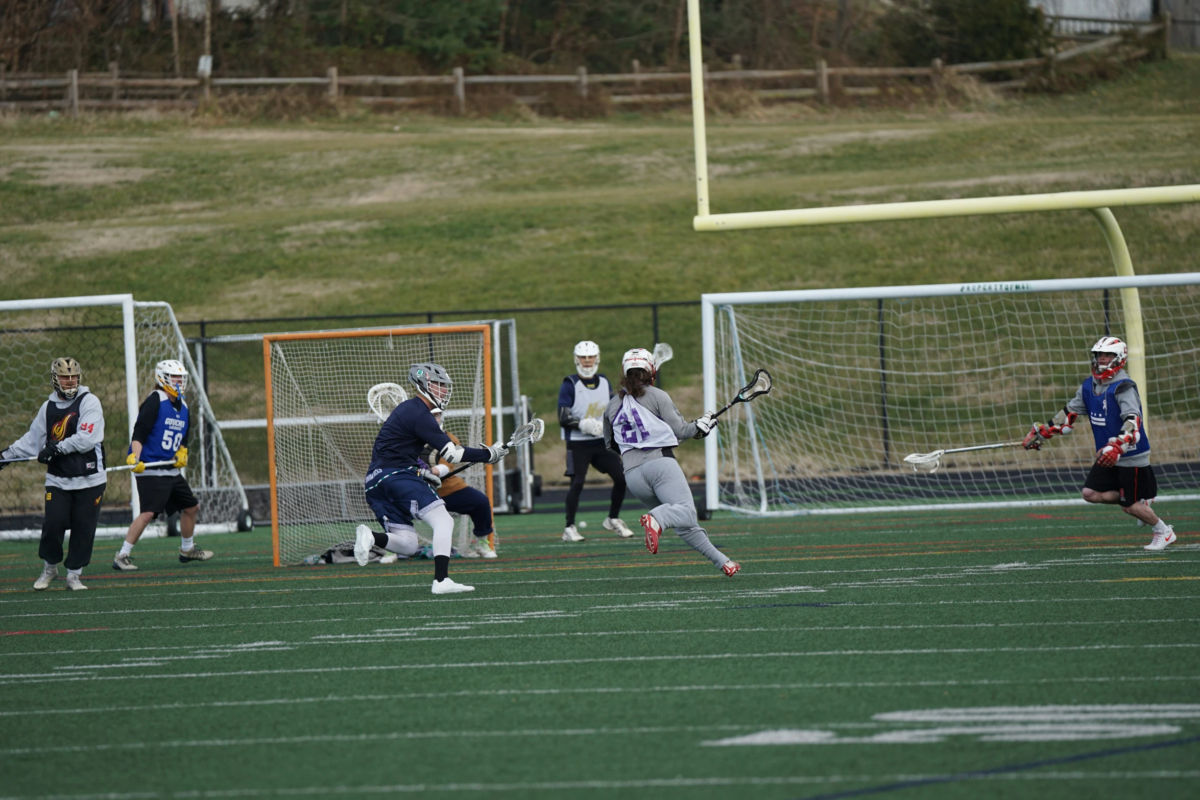 several lacrosse players playing in a field