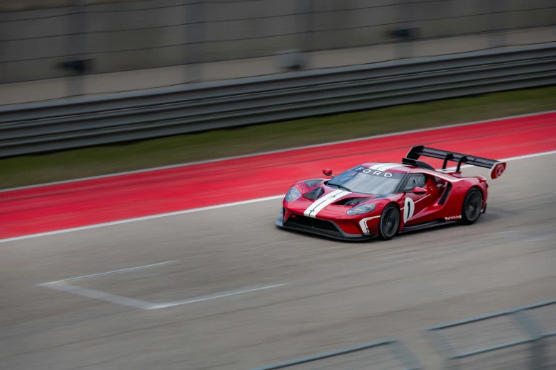 red race car driving on the track at high speeds