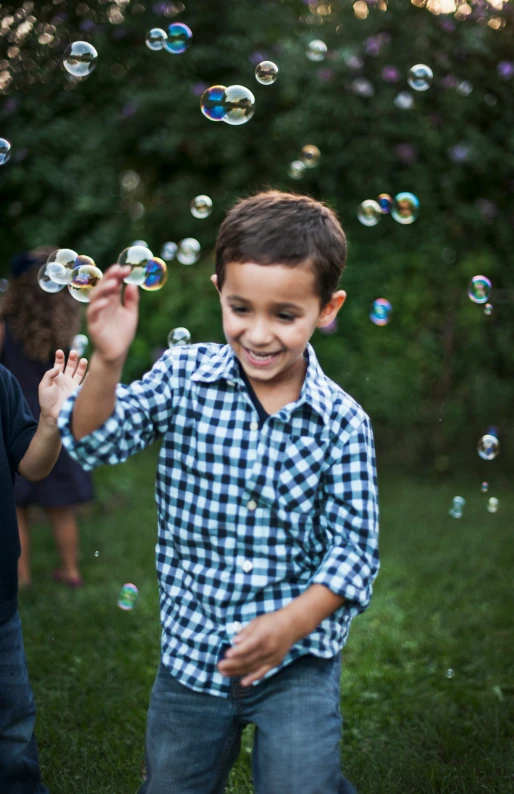 a  playing in a field with bubbles