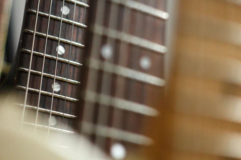 the frets of an acoustic guitar are visible through the lens