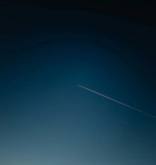 an airplane is flying high in the sky with the moon behind it