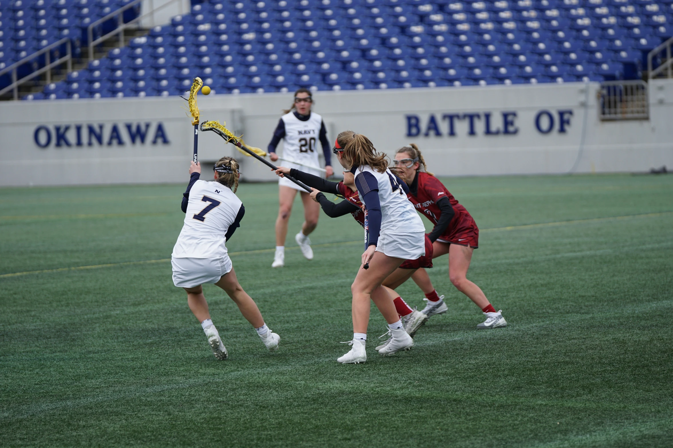 some girls playing hockey with each other in the field