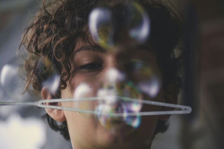 an image of a boy blowing bubbles on the air
