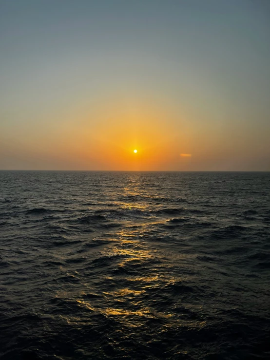the sun is rising over the water as seen from a boat