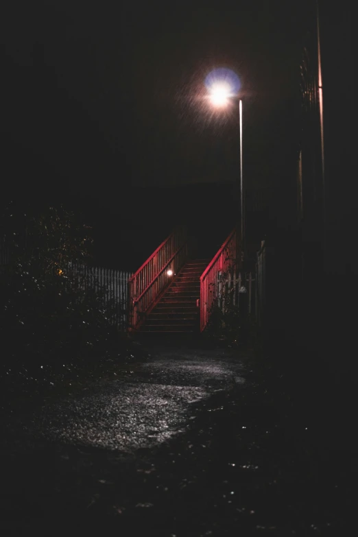 a dark night view of a lit stairway with the lights on