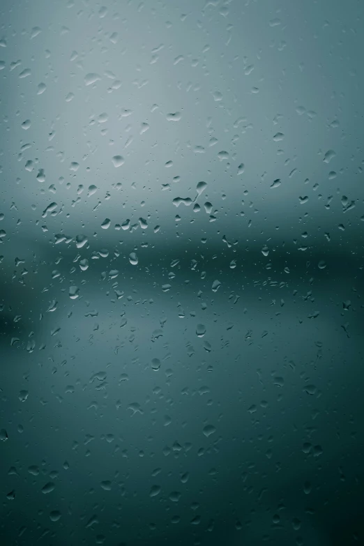 rain drops on the glass window and reflecting a body of water