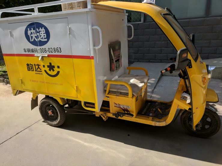 two people driving small yellow cart on street