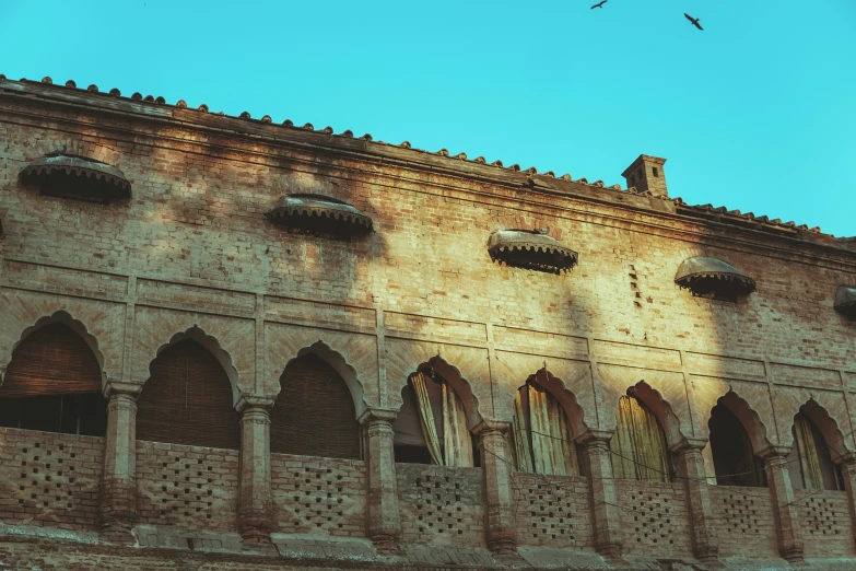 an old building has birds flying over the windows