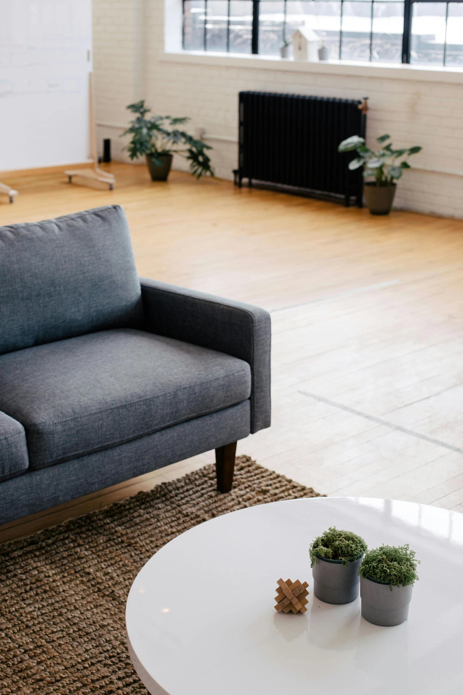 two pots are on the edge of the coffee table near the sofa