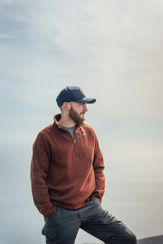 the man wearing a hat stands on top of a hill