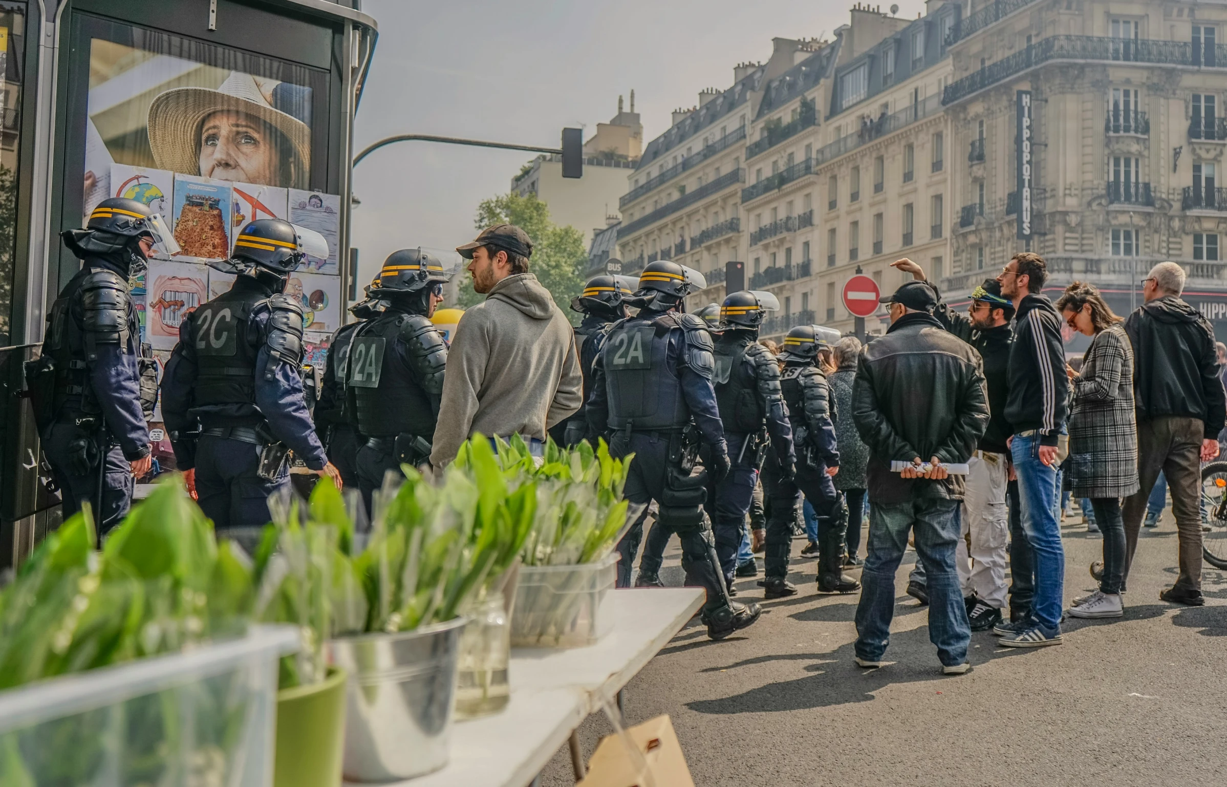 the police officers stand on a side walk near some grass and plants