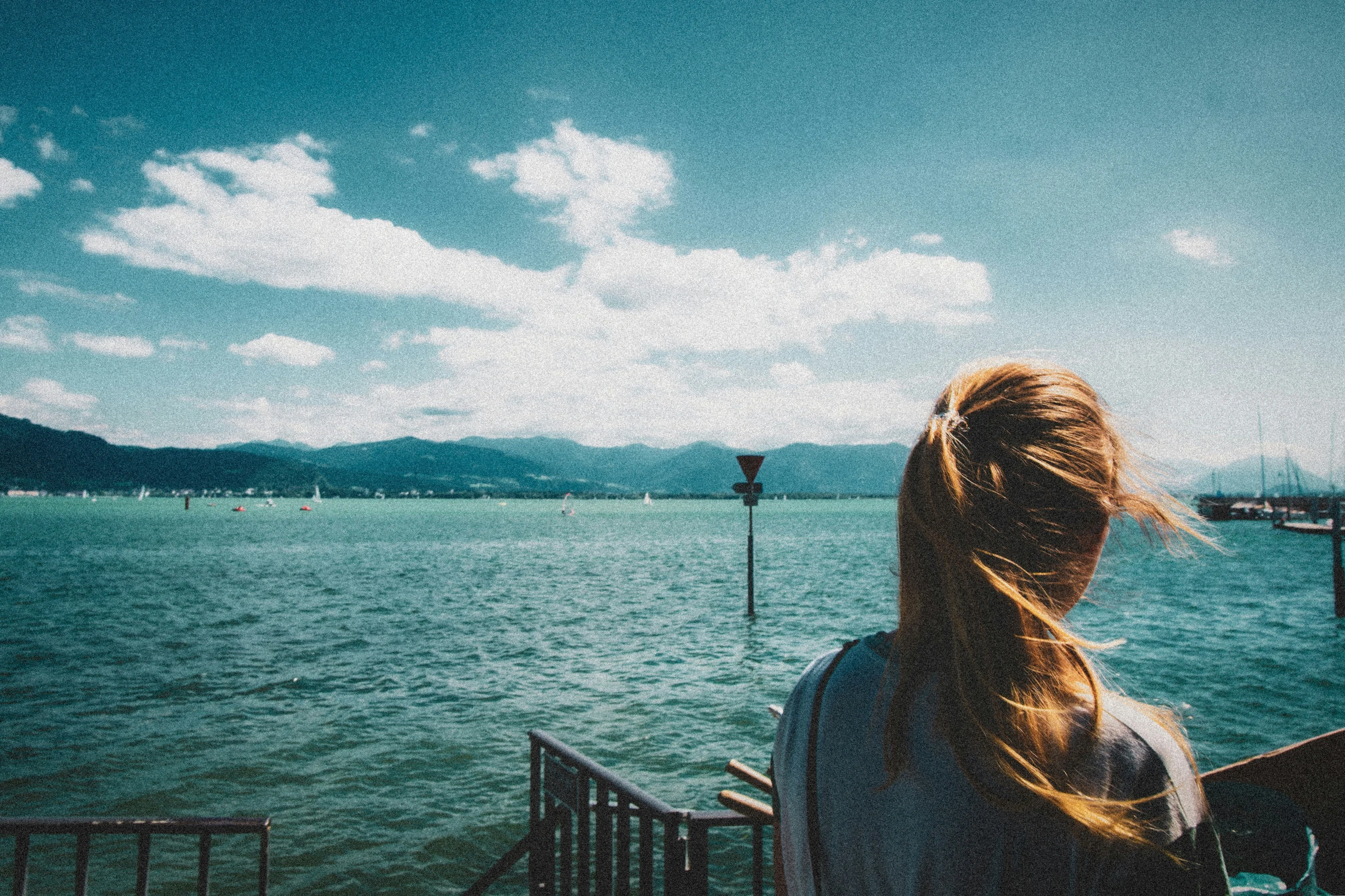 a beautiful woman stands in front of the ocean