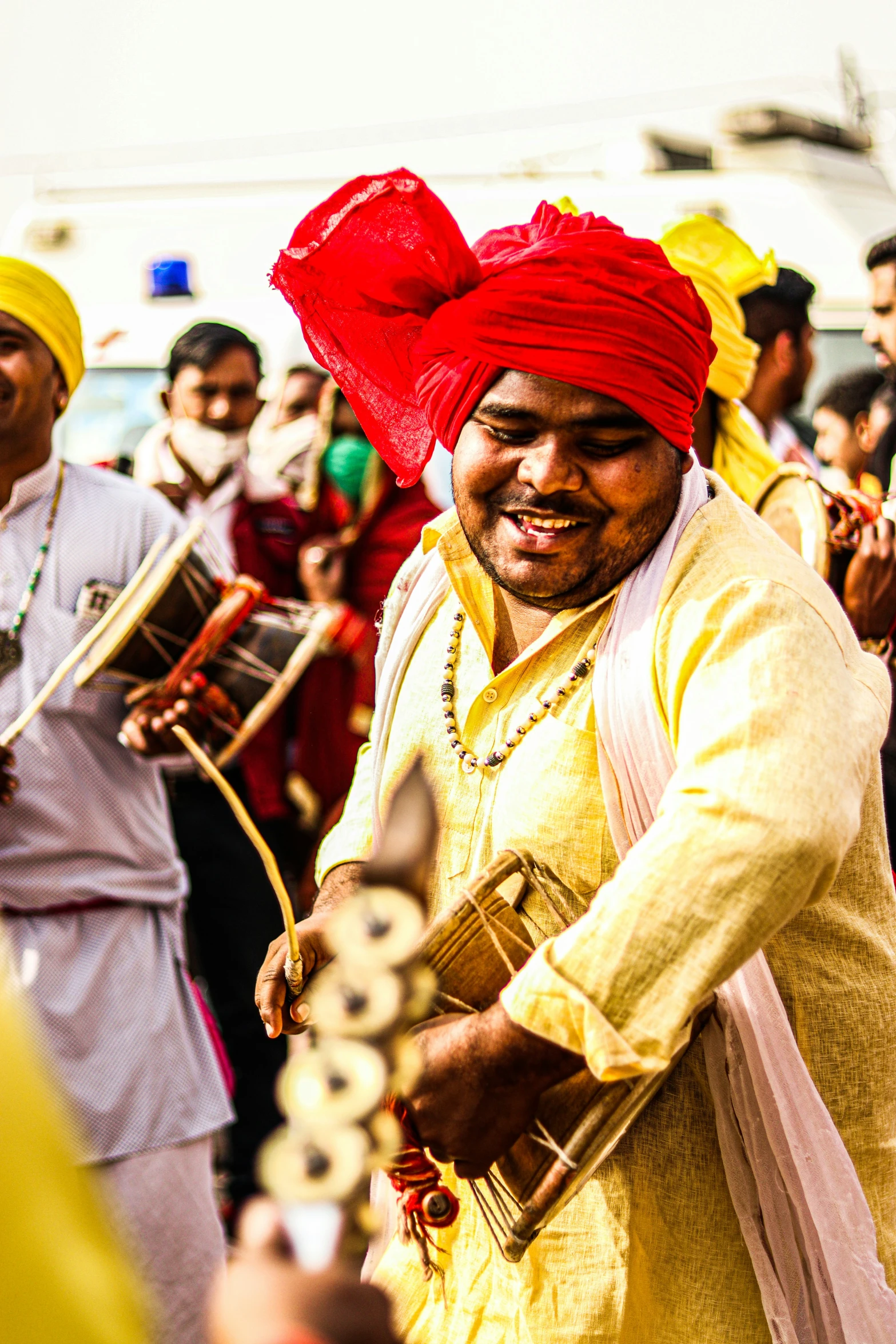 a man holding a instrument while standing near other people