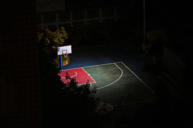 a basketball court at night with lights on it