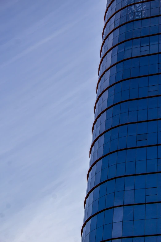 a tall glass building with a sky in the background