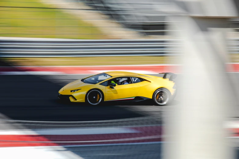 a yellow sports car driving around the track