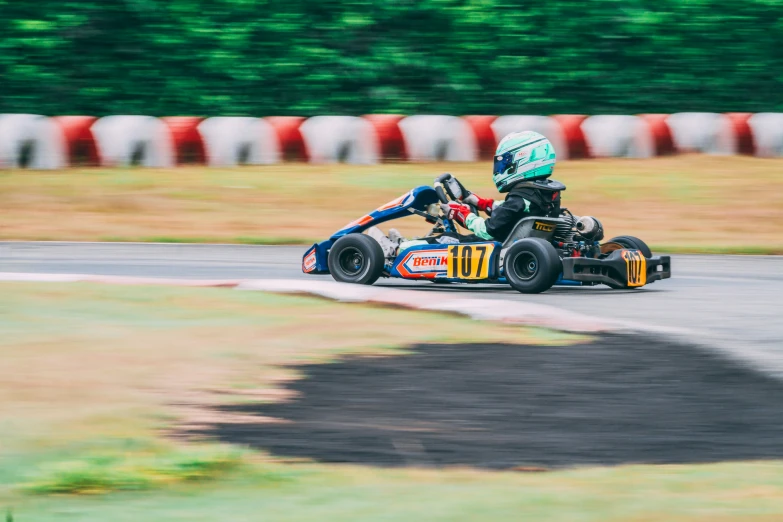 a racing car drives along a track with the driver behind