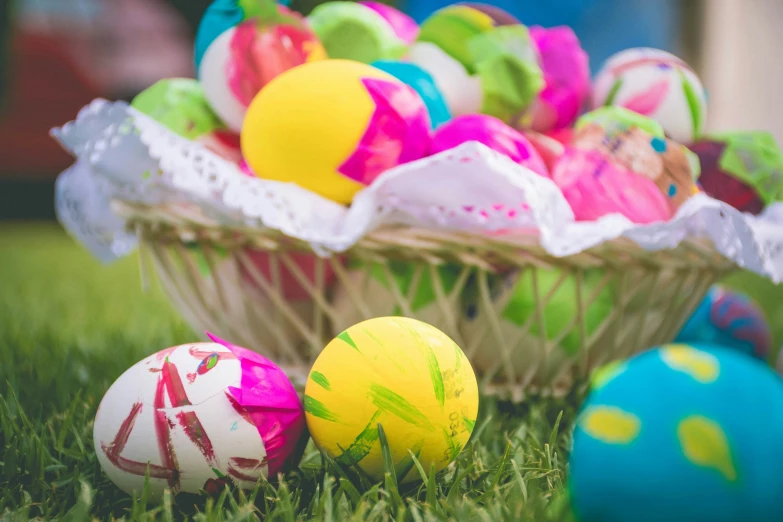 some balls and other items in a basket on some grass