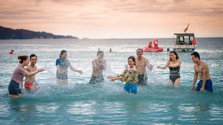 group of people in the ocean next to a boat