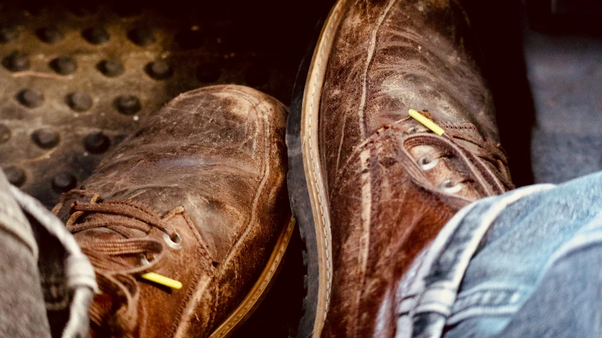two brown shoes standing next to each other