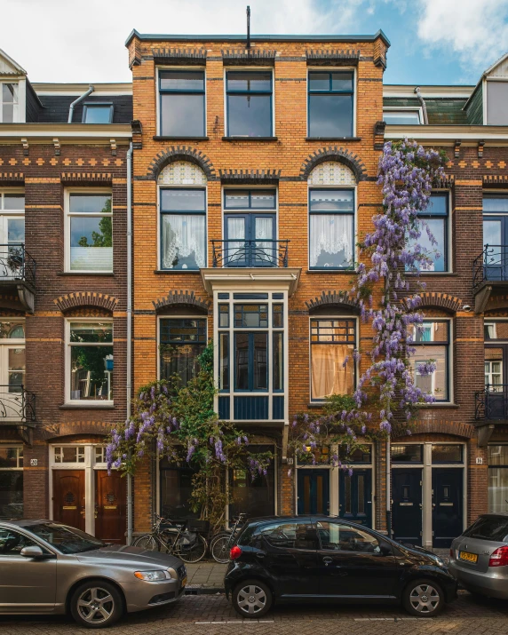 cars parked in front of a tall brick building