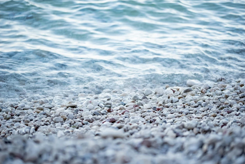 sea water bubbles coming in onto the rocky beach shore