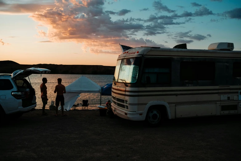 a white bus sitting next to a body of water