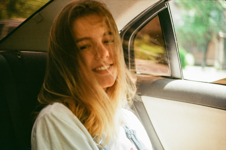 an image of a young woman in a car smiling