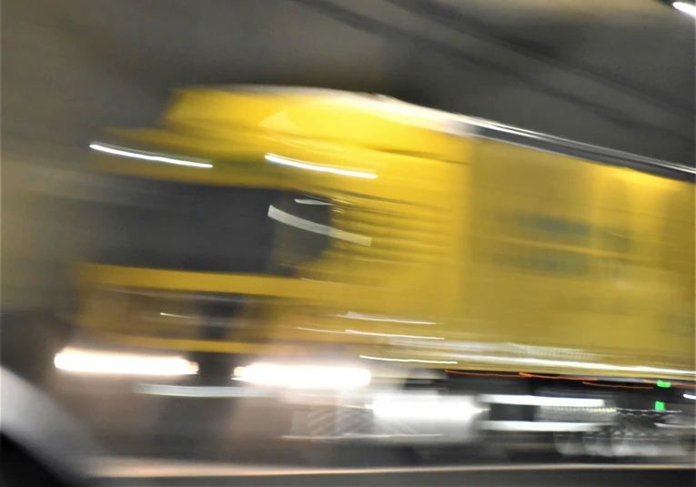 a blurry po of a yellow train traveling down tracks