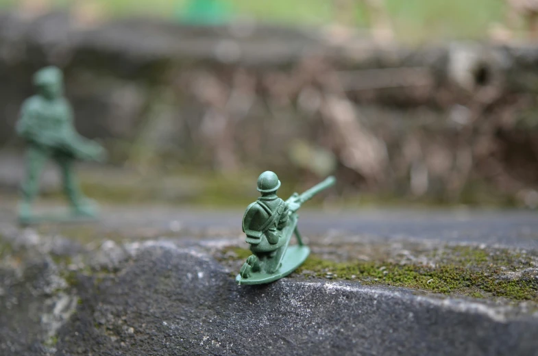 toy figurines in different shapes and sizes displayed on top of mossy rock