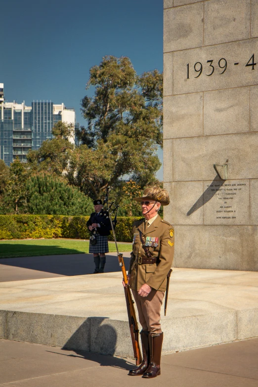 a male in a uniform is holding a rifle