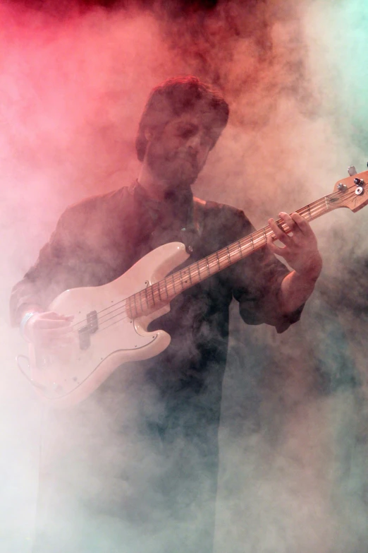 a close up of a person playing a bass guitar