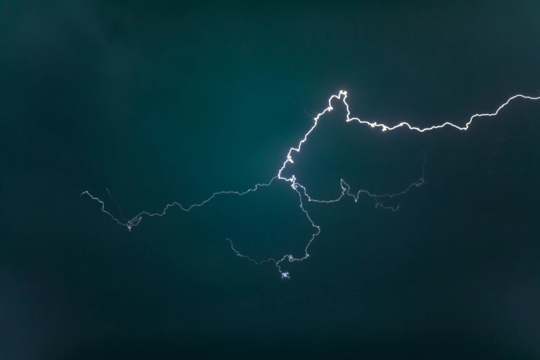 a dark and stormy blue sky with bright lightning and clouds