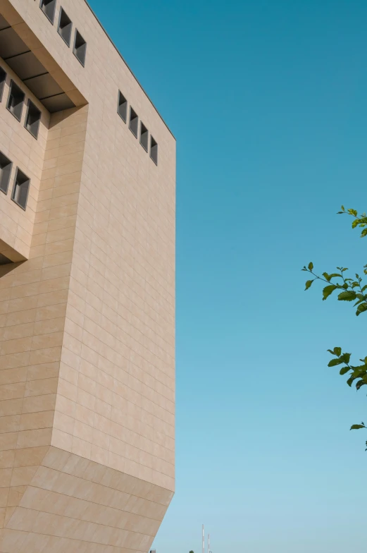 a large white building near a green tree