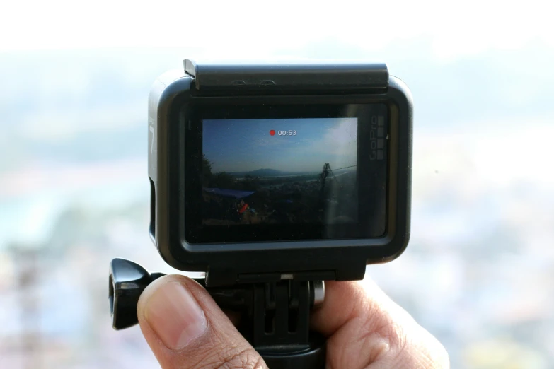 someone holding up a camera to take a picture of a mountain