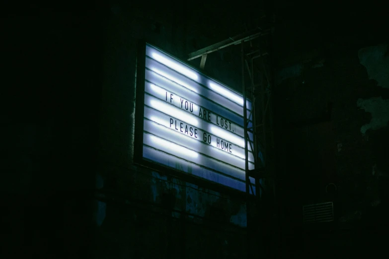 an illuminated billboard in the dark for a concert